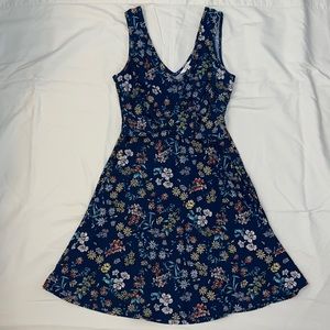 Sleeveless navy blue dress with floral print with twist at front.